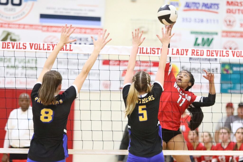 Williston's Chanitey James with a hit against Newerry's Sarah Watson (8) and Hanna Templeton (5) on Tuesday.