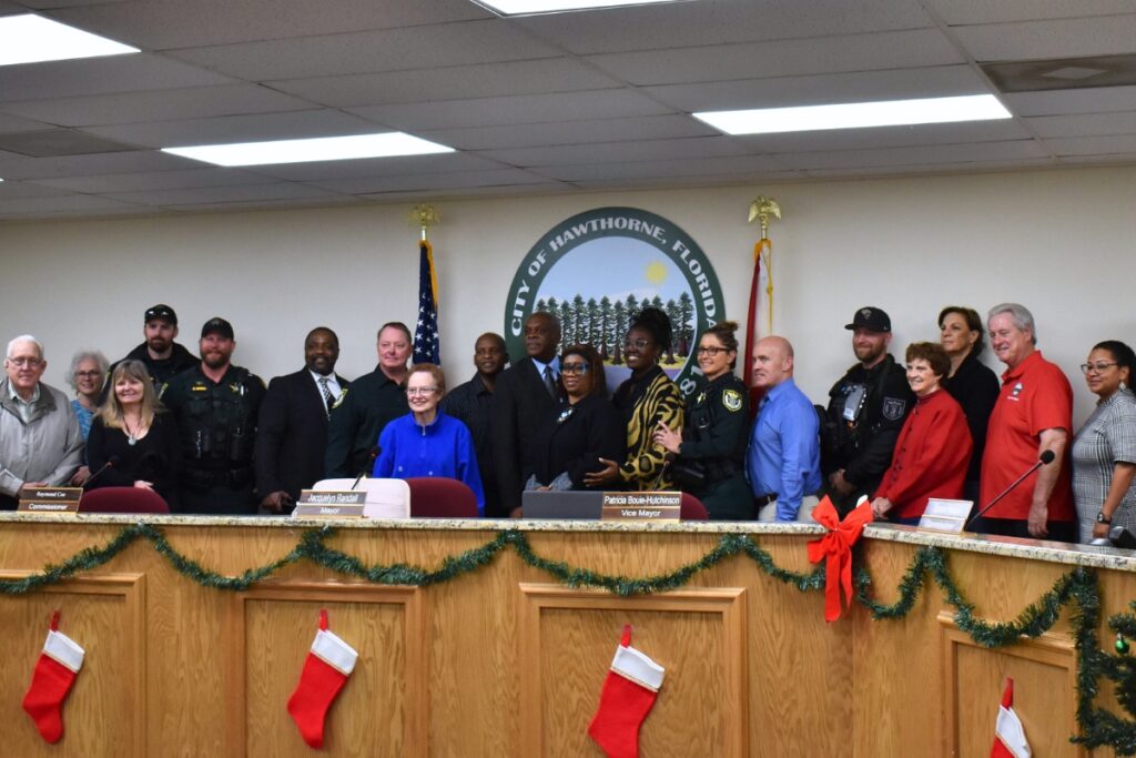 Attendees of the grand opening pose behind the city commission's dais.