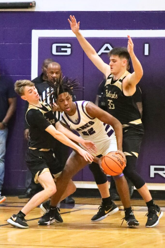 Buchholz's Blake McClain (4) and Palmer Walton (35) defend Gainesville's Cornelius White on Friday.