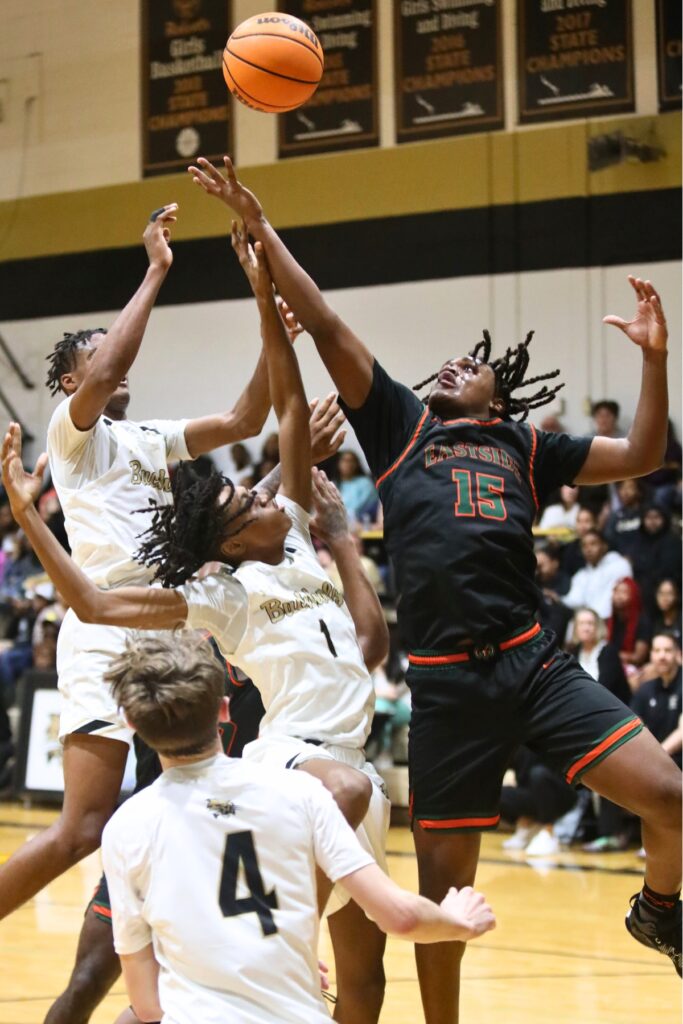 Buchholz's Zion Newkirk (24) and Cedric Collins (1) battle Eastside's Jerrel Comer for a rebound.