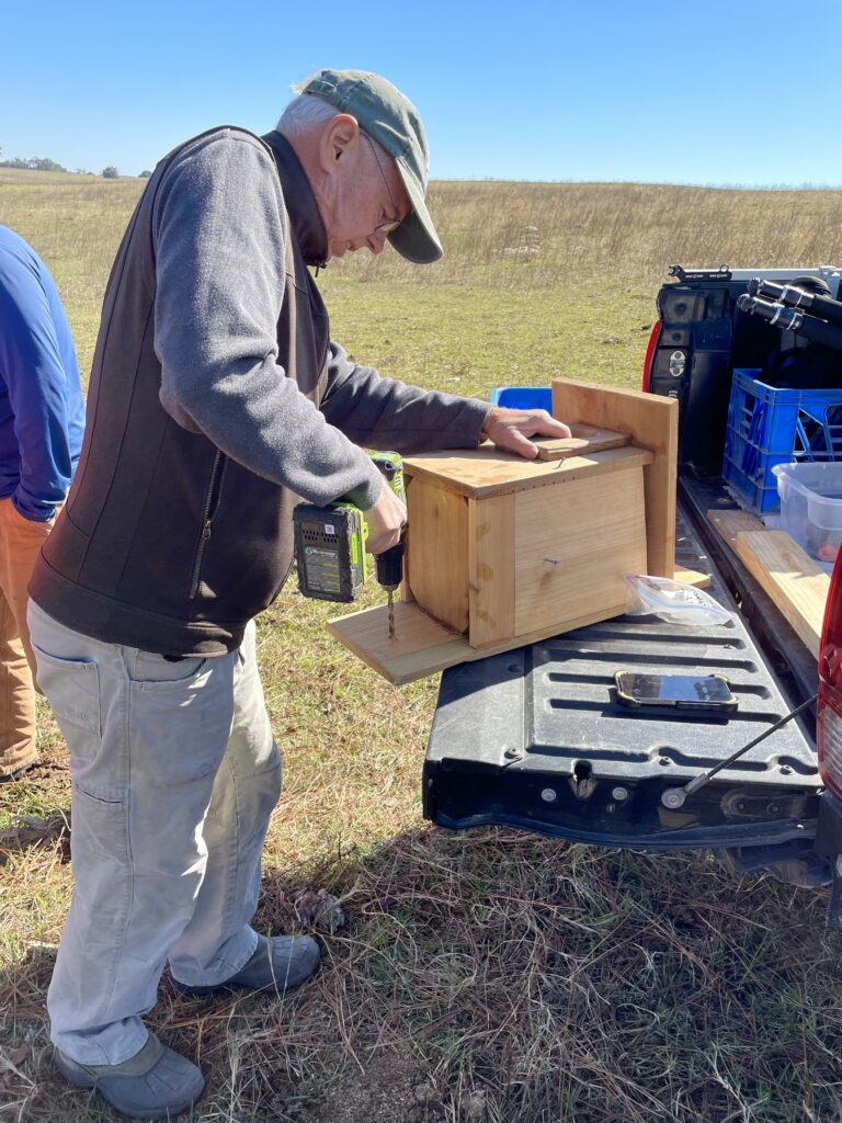 Eric Amundson drills holes in a new kestrel box to install on county property near Watermelon Pond. 