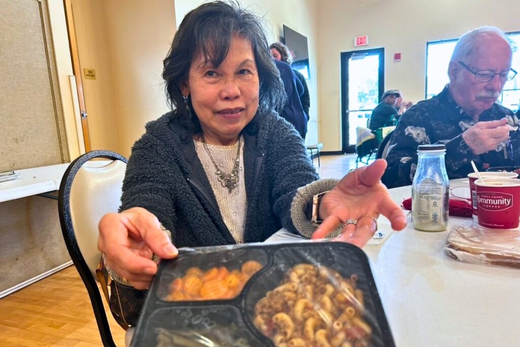 Fe Flor Phangvivat displays the meal she was served at the congregant lunch at Elder Care’s Senior Recreation Center.