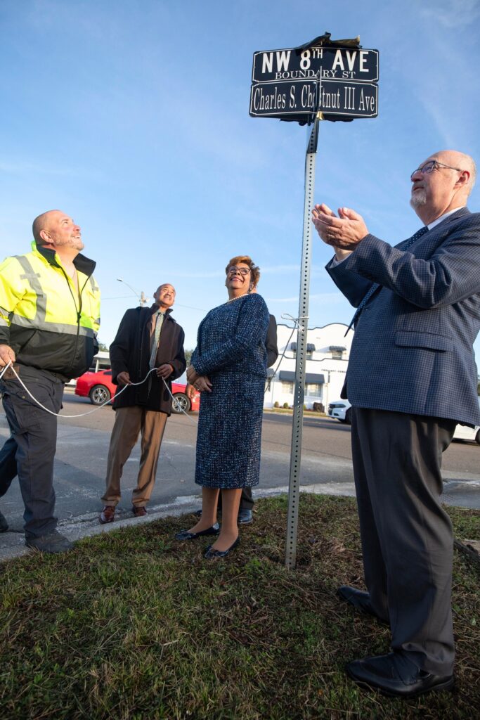 Gainesville Mayor Harvey Ward, far right, applauds as the new sign is revealed.