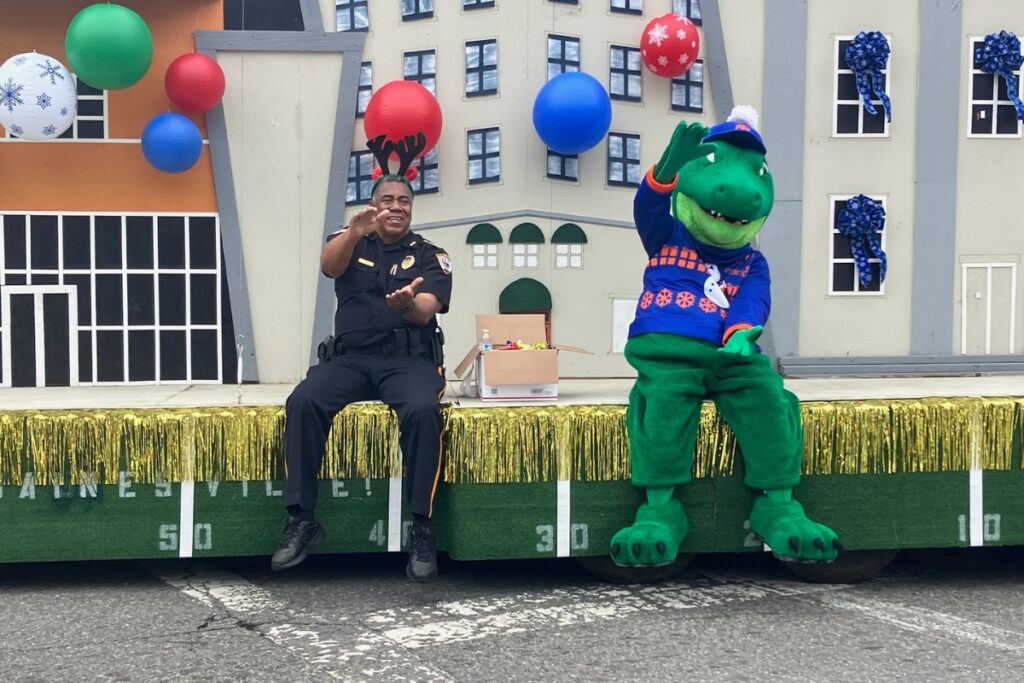 Gainesville Police Chief Lonnie Scott with the UF Gators mascot doing the Gator Chomp in A Very GNV Holiday Parade on Saturday.