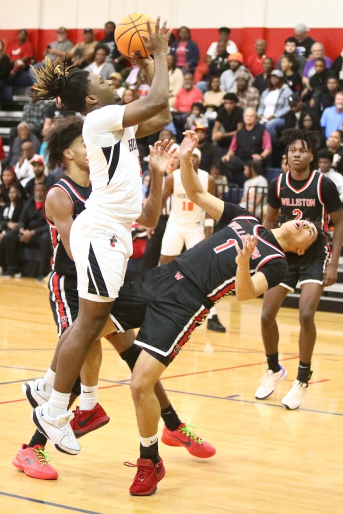 Hawthorne's Caleb Rollerson drives against Williston's Aramys Rodriguez.