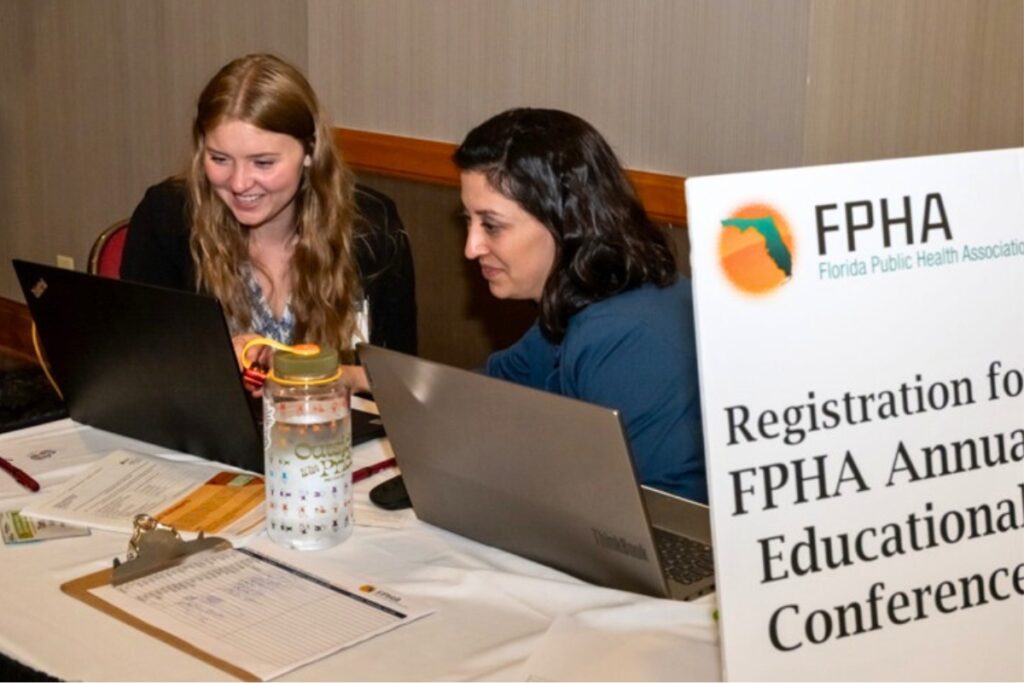 Maddy Campellone, left, and SRAHEC executive director Sarah Catalanotto register attendees at a recent conference SRAHEC helped to organize.