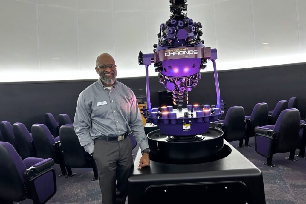 Planetarium director James Albury stands alongside the Chronos Go To Space Simulator at the Kika Silva Pla planetarium.