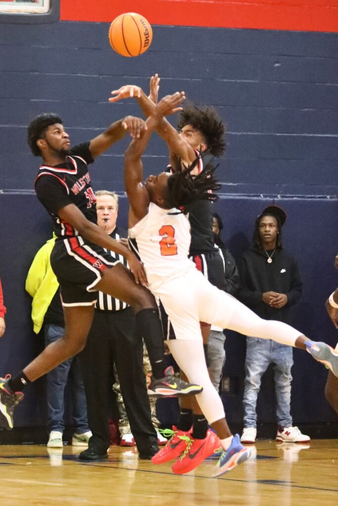 Williston's Quincy Parker (14) and Kyler Lamb (10) break up Hawthorne's Alvon Isaac's shot attempt.