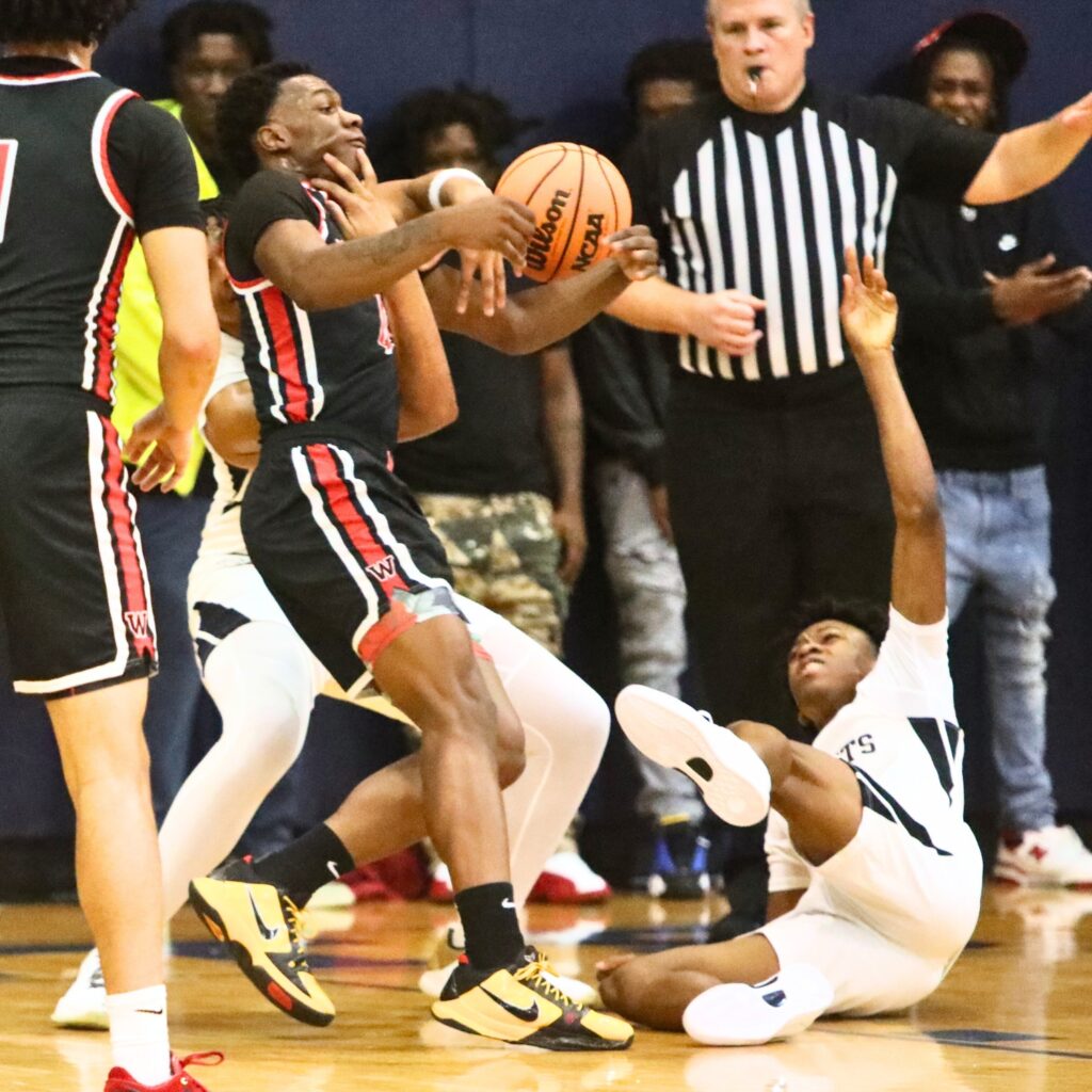 Williston's Reggie White gets a hand to the face from Hawthorne's Leland Johnson.
