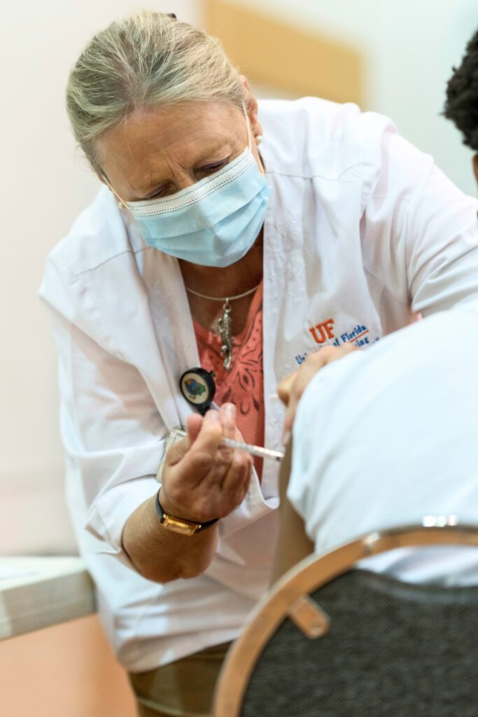 A UF Health worker giving a vaccine shot at Mt. Carmel Church.