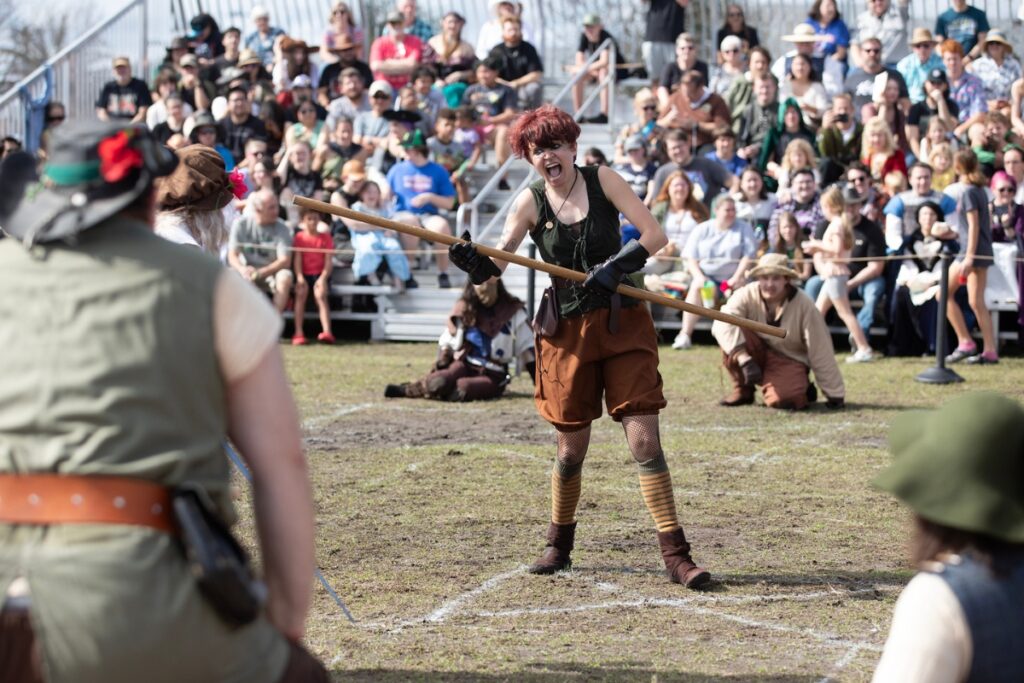 A fighter bellows out a yell before advancing upon her opponent.