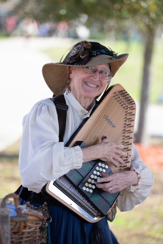A musician pauses and grins while playing her instrument.