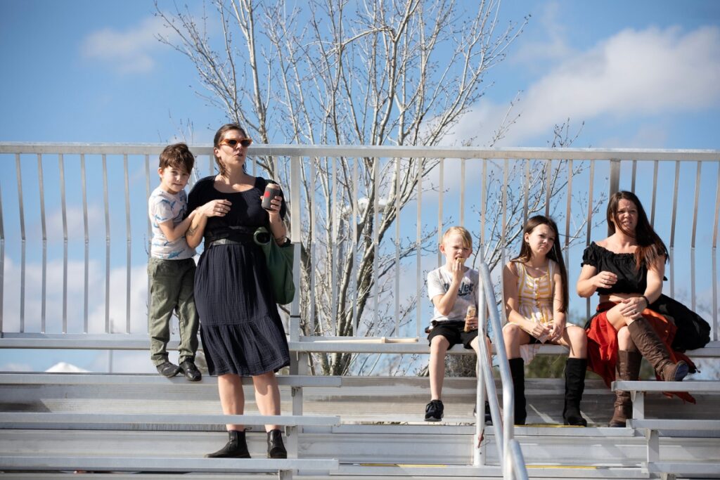 Attendees find seats in the bleachers before the Living Chessboard tournament.