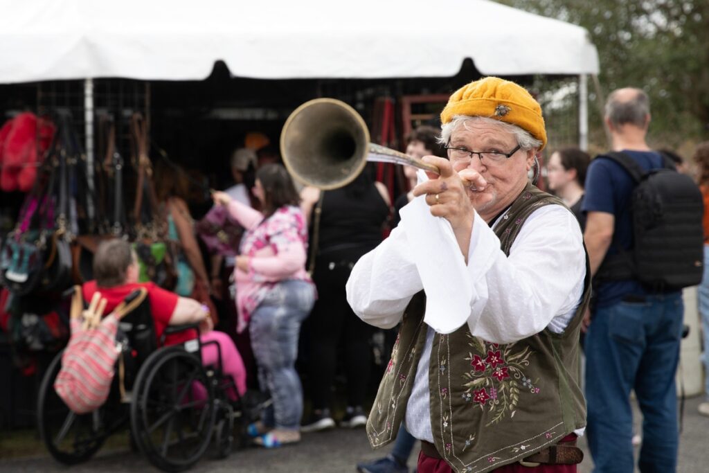“Bob DaVinci” imitates fart noises with his trumpet to entertain the crowd.