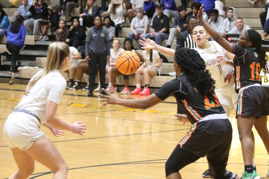 Buchholz's Jamison Cardwell passes around Eastside's Merveille Namusura to teammate Kaylynn Perry.