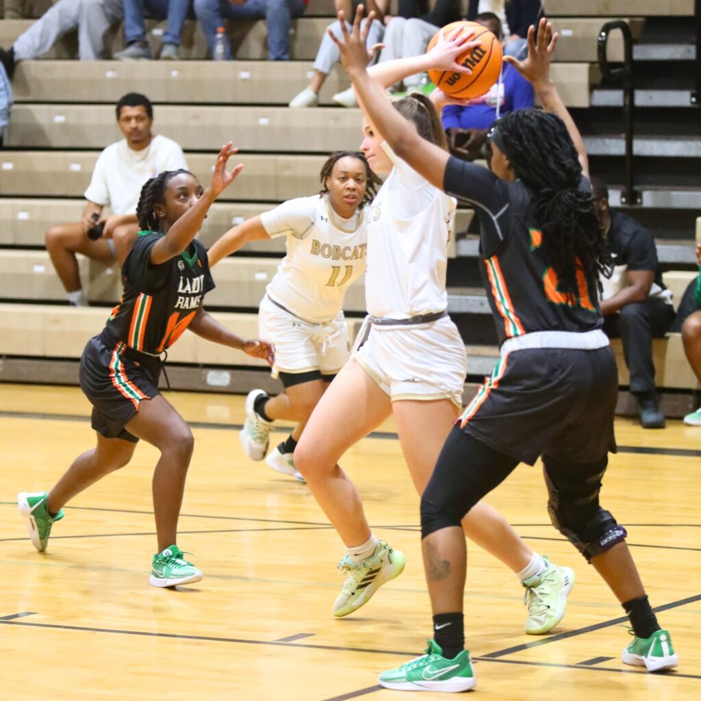 Buchholz's Kaylynn Perry finds a teammate to pass to between Eastside's Akira Martin (14) and Precious Marshall (21).