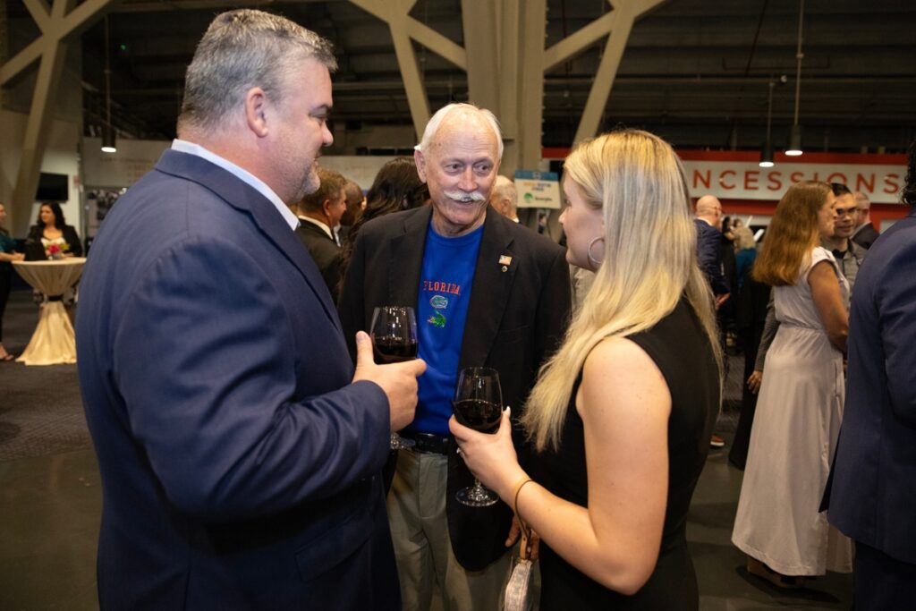 City of Alachua Mayor Gib Coerper, center, mingles with guests in the Stephen C. O’Connell Center atrium before the start of the event.