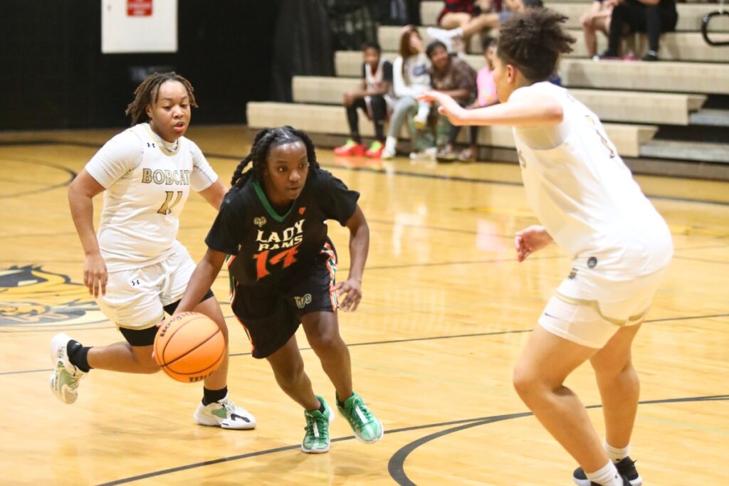 Eastside's Akira Martin dribbles between Buchholz's Kamyrn Harper (11) and Jamison Cardwell (1).