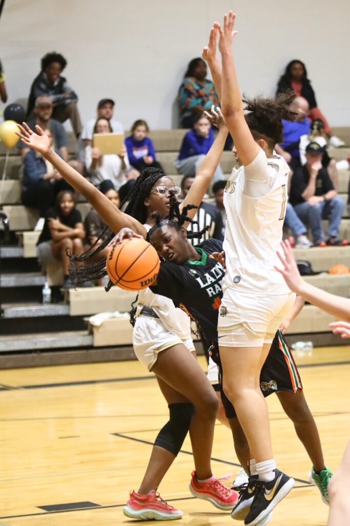 Eastside's Akira Martin gets fouled after getting sandwiched by Buchholz's Tionna Wilkinson and Jamison Cardwell (1).