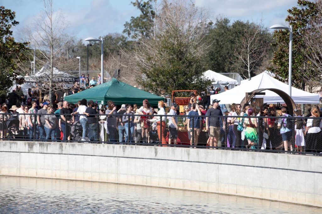 Festival attendees walk along the Depot Park pond.
