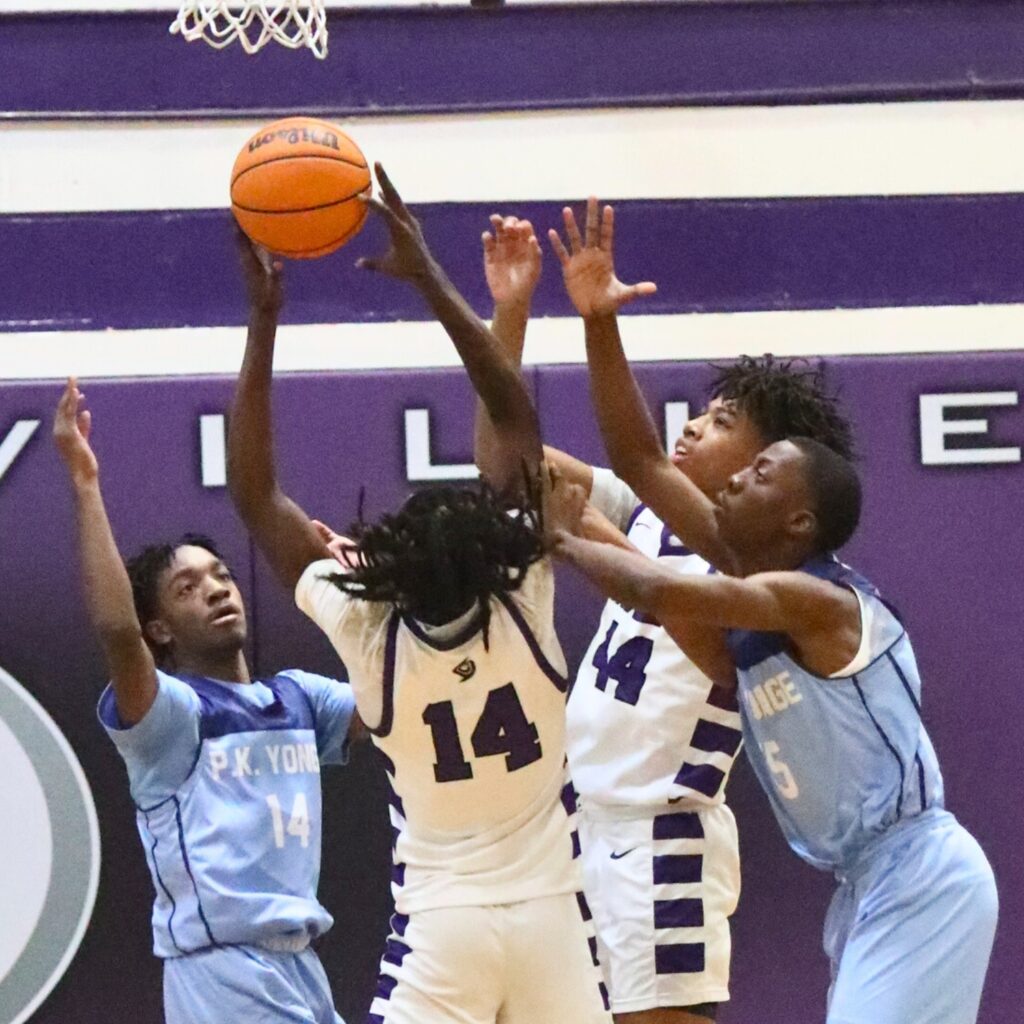 Gainesivlle's Craig Thomas Jr. grabs a rebound against P.K. Yonge's Triston Dye (14) and Mareon Bannister (15).