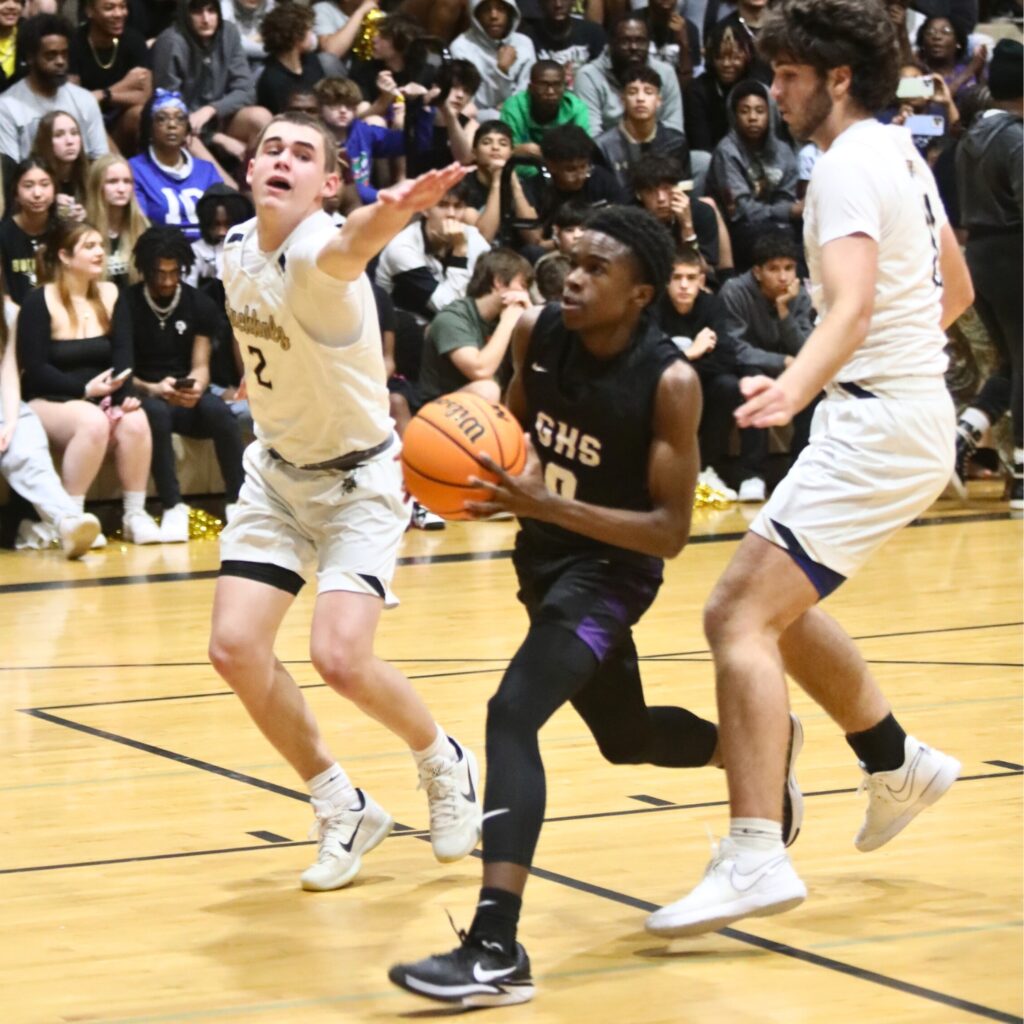 Gainesville's Brian Smith drives to the basket past Buchholz's Nate Muchnick and Peyton Warring (2).