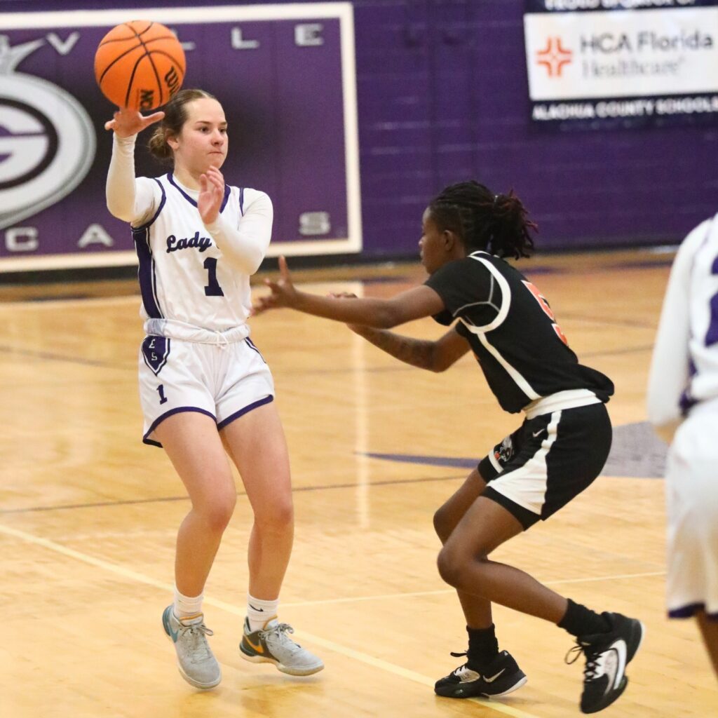 Gainesville's Taylor Mullins with a no-look pass against Hawthorne's Zakena Ealy.