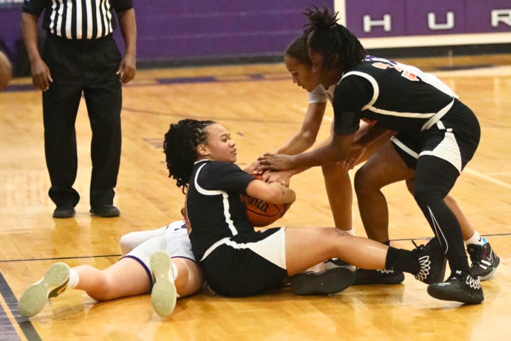 Hawthorne's T'Myrah Carter and Lakijah Brown (3) tie up the ball with Gainesville's Jayden Terry.