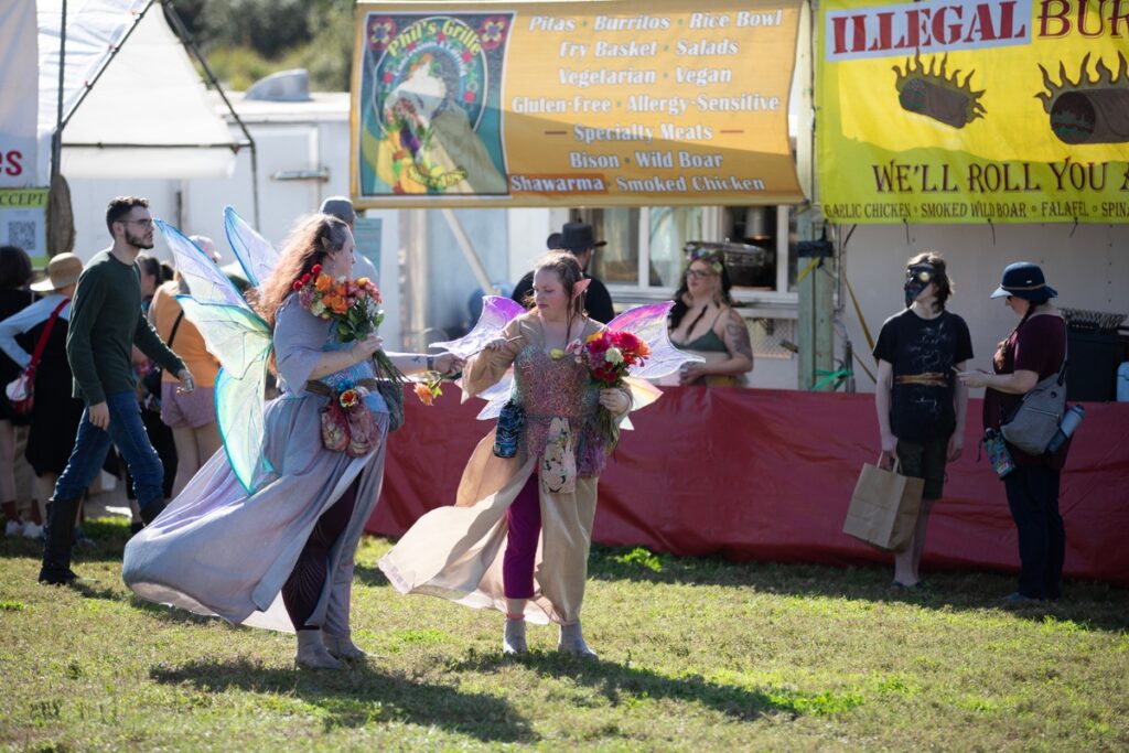 Lisa Mahoney, AKA “Dewberry,” of Gainesville, left, and Holly Adams, AKA “Misty,” of Newberry, arrange the fresh flowers they later handed out to children.