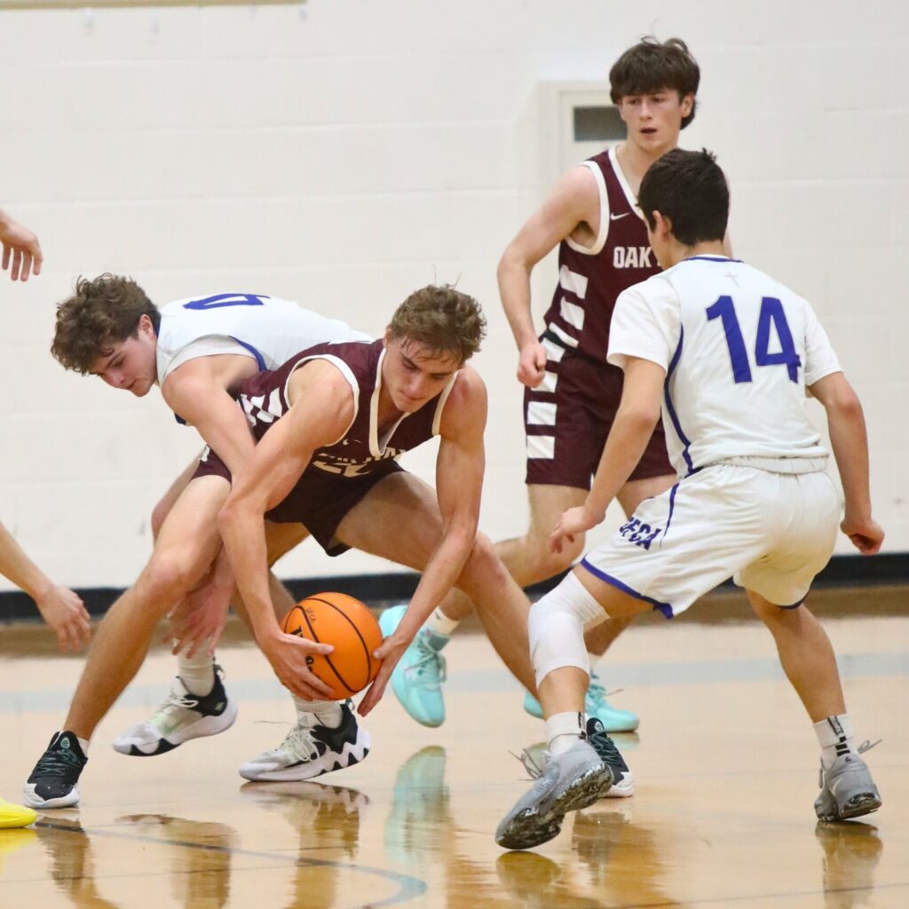 Oak Hall's Andrew Powell secures the ball from St. Francis Catholic's William Collett.