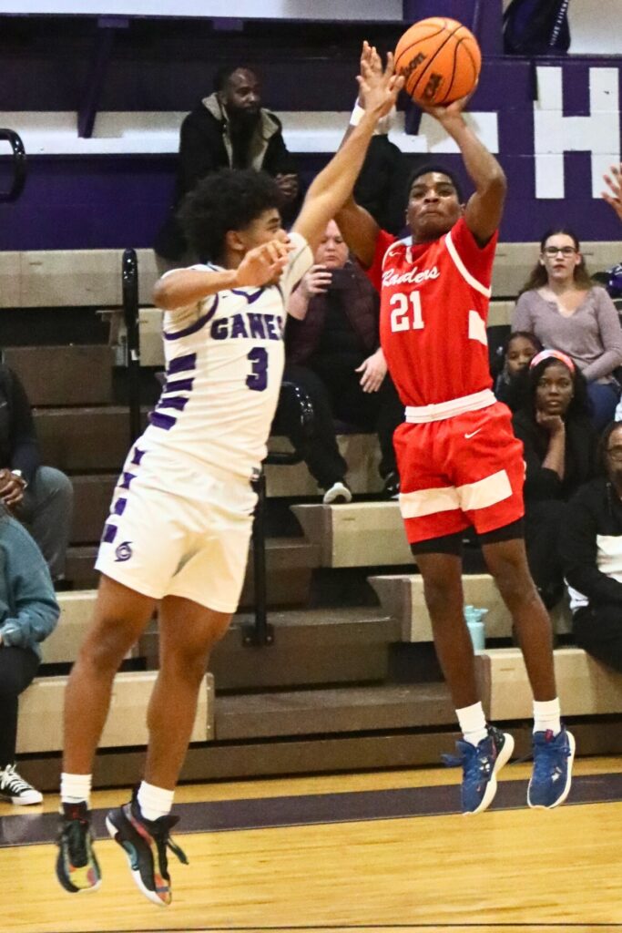 Santa Fe's Braylon Guyden launches a 3-point shot over Gainesville's Jacob Wright.