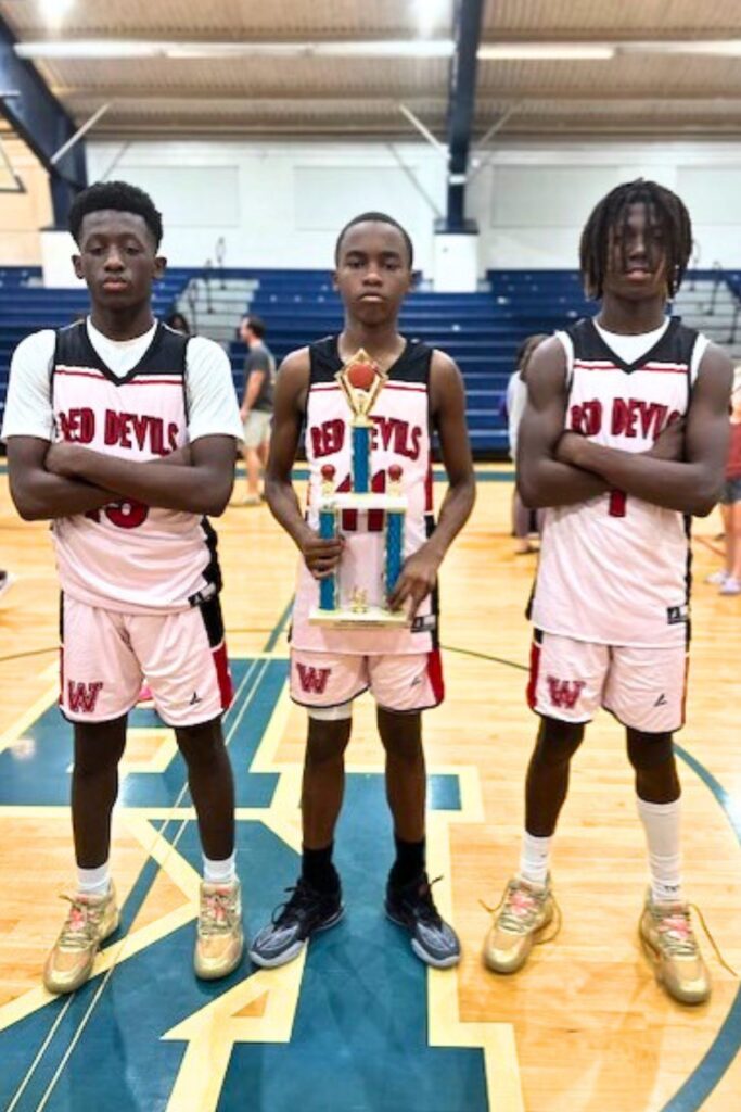 Williston's Jacques Edwards (15), Kyson Chevars (11) and Treston Woody Jones (1) with the middle school championship trophy.
