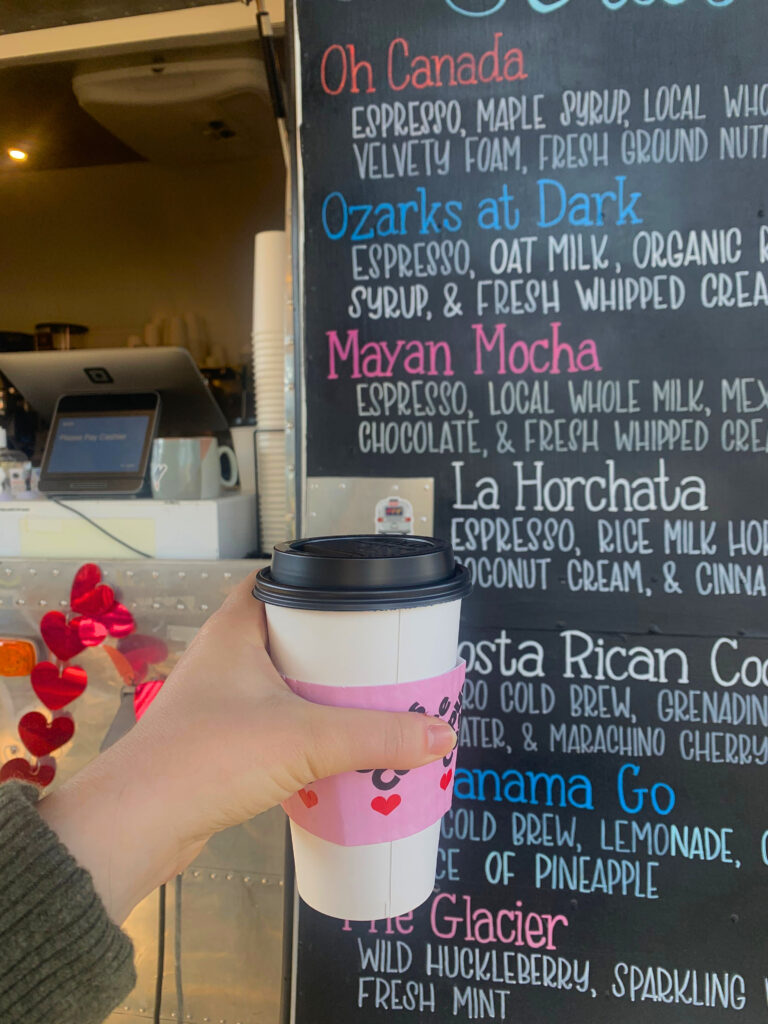 A cup of coffee in front of the Opus Coffee Airstream.