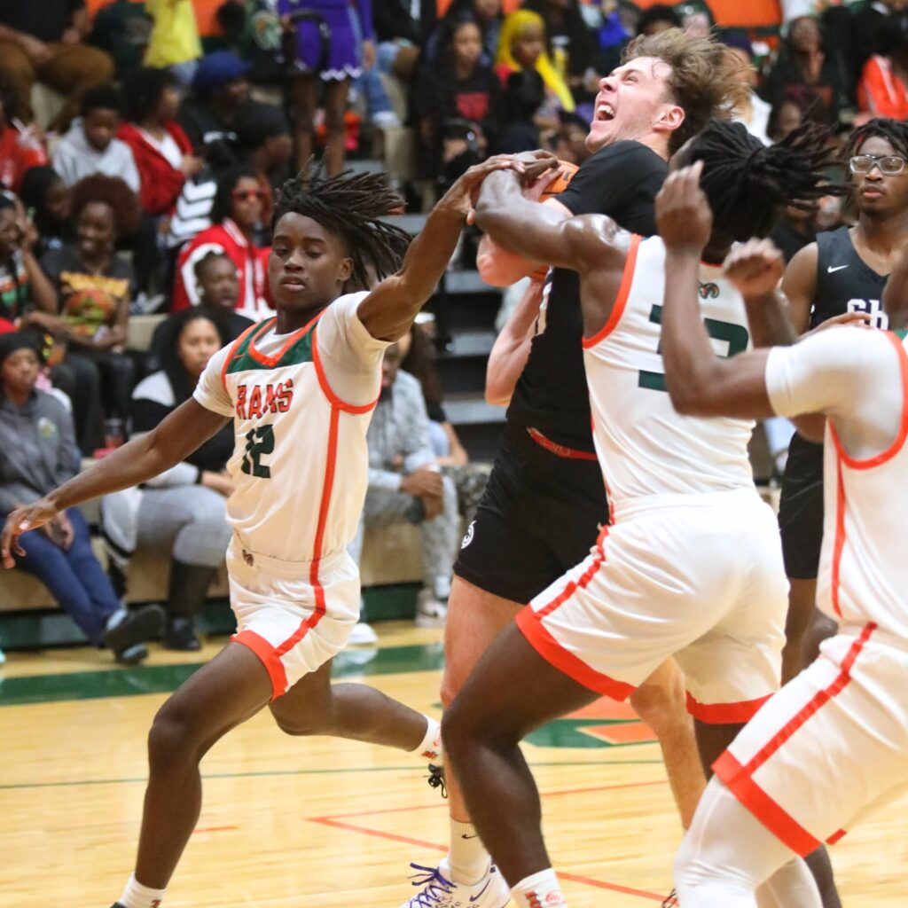 Eastside's Lorenza Simmons (12) and Davion Pugh (33) attempt to block a shot by Gainesville's Anthony Leivonen.