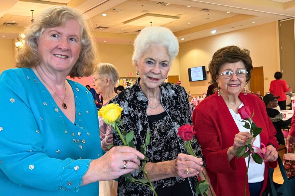 Elizabeth Williams, Pat Thomas, and ruth Scully stand with the roses they were given at this year’s Senior Prom at the Senior Recreational Center.