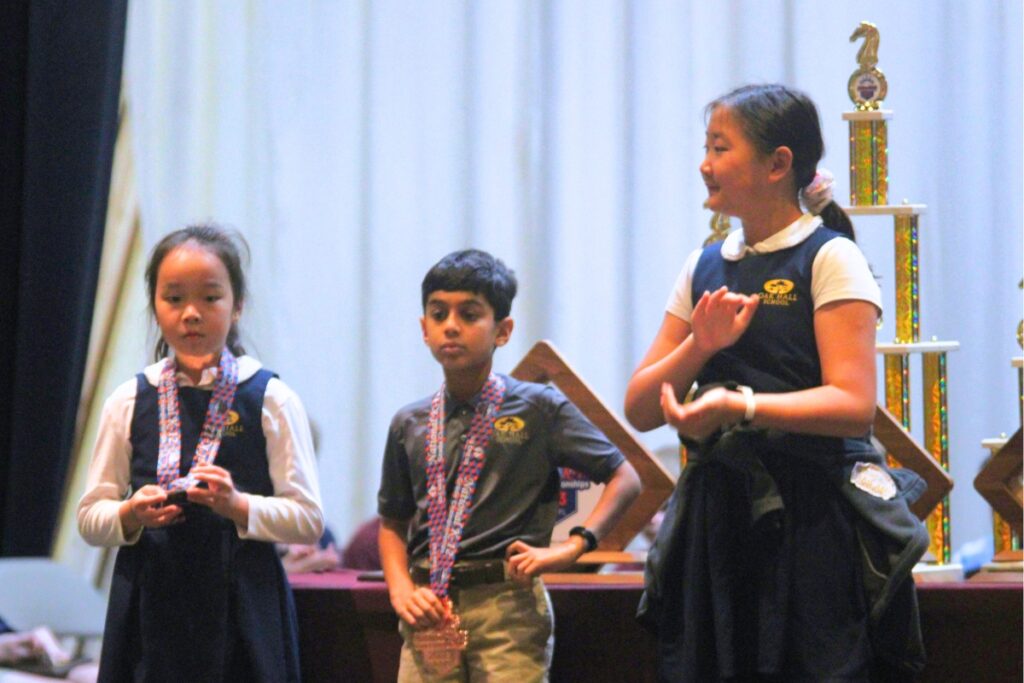 (From left) Celine, Akosh and Sophie receive special accolades for their chess accomplishments.