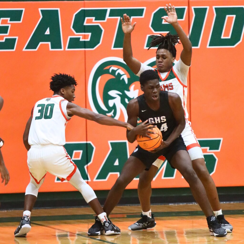 Gainesville's David Osho protects the ball against Eastside's Lemarion Houston (30) and Jarrel Comer (15).