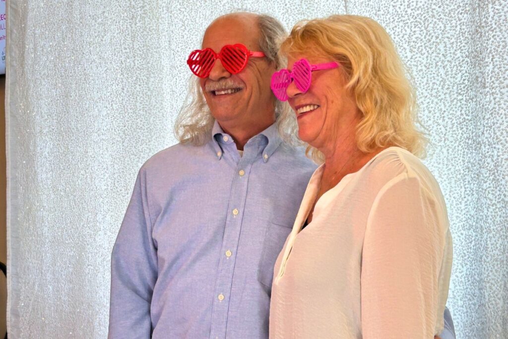 Hubie Jacques and Marsha Belgrade show off their special glasses before taking a picture in the Photo Booth set up for the event.