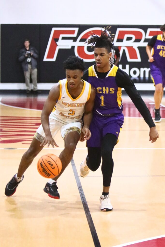 Newberry's Jacob Green dribbles past Union County's Gavin Jenkins.