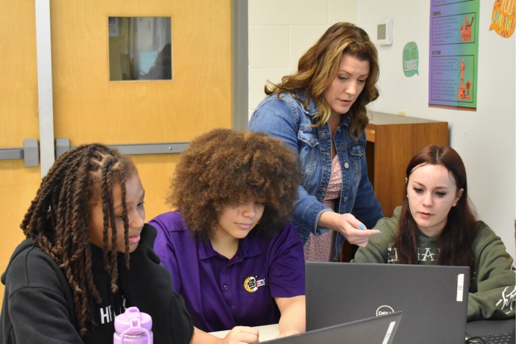 Nicole Tart helps (L-R) Michelle Allen, Emily Sincock and Marley Deedrick as they finish a script.