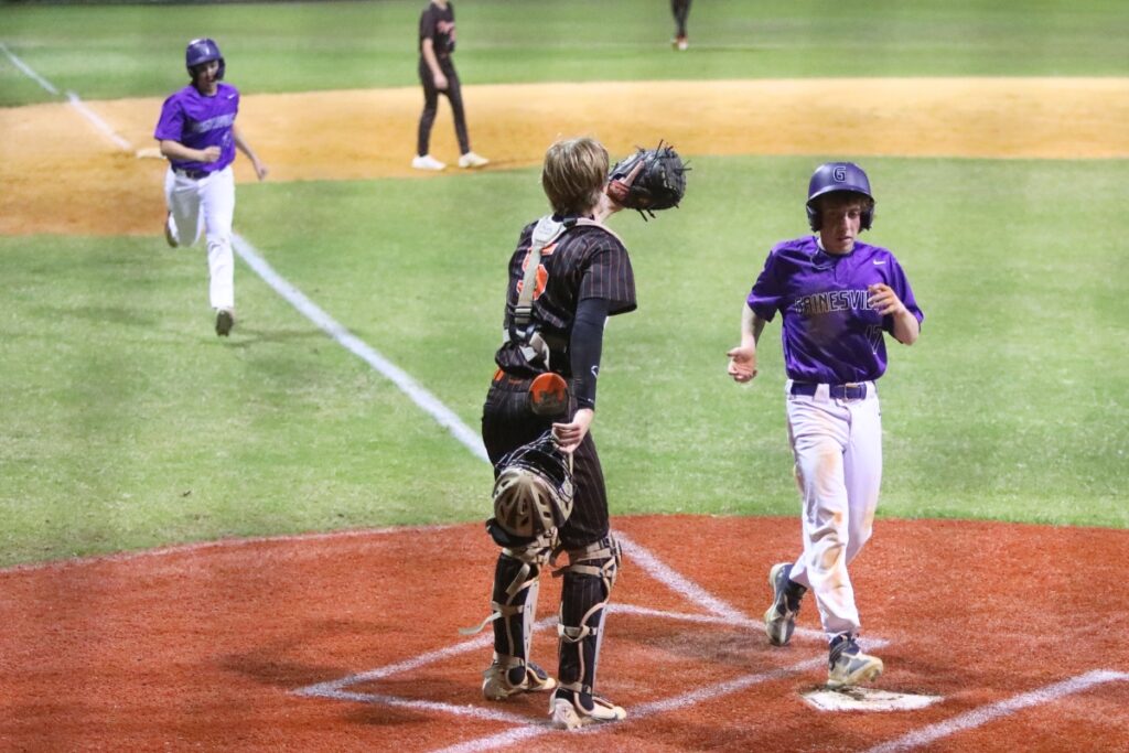Gainesville's Billy Holdsworth (17) and Anthony Dang score to put the Hurricanes ahead 6-4 in the bottom of the fourth inning against Trenton.