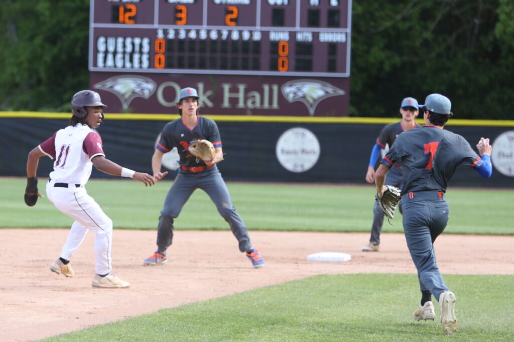 Oak Hall's Darion Medley (11) gets caught in a run down between second and third base as P.K. Yonge's Nick Roach (7) would throw to Micah Gratto for the first-inning tag out.