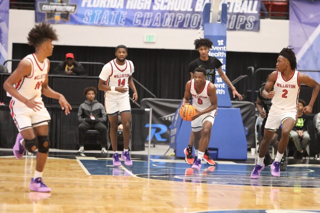 Williston's Reggie White brings the ball down the floor after a rebound against Chipley in the Class 1A State Semifinal game at FP Funding Center in Lakeland.