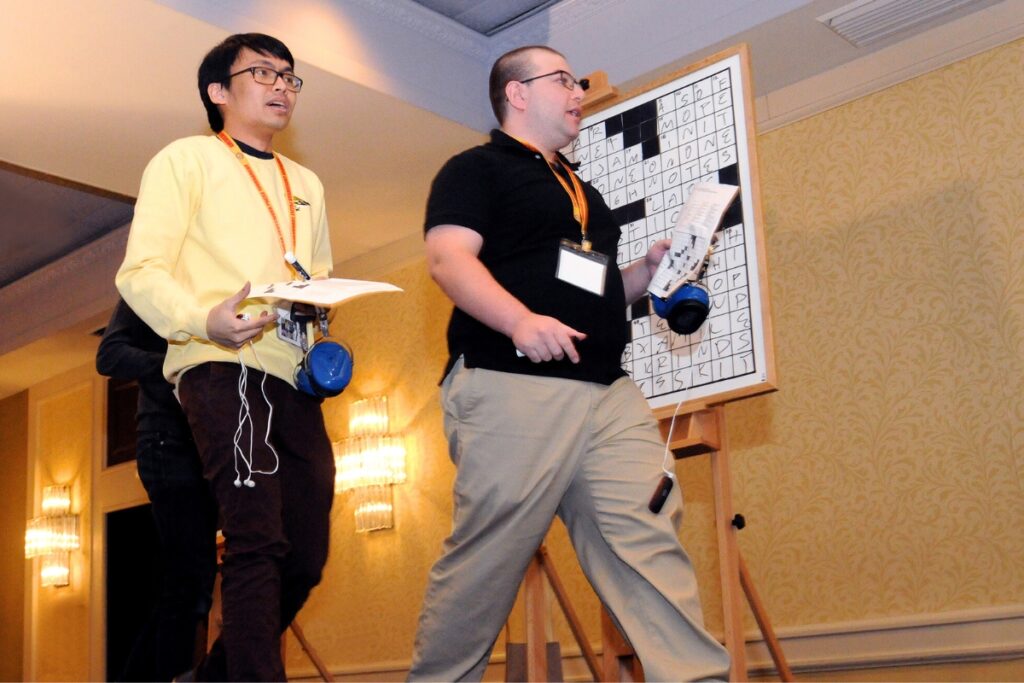 David Plotkin (right) and Paolo Pasco walk off stage after completing the final crossword puzzle.
