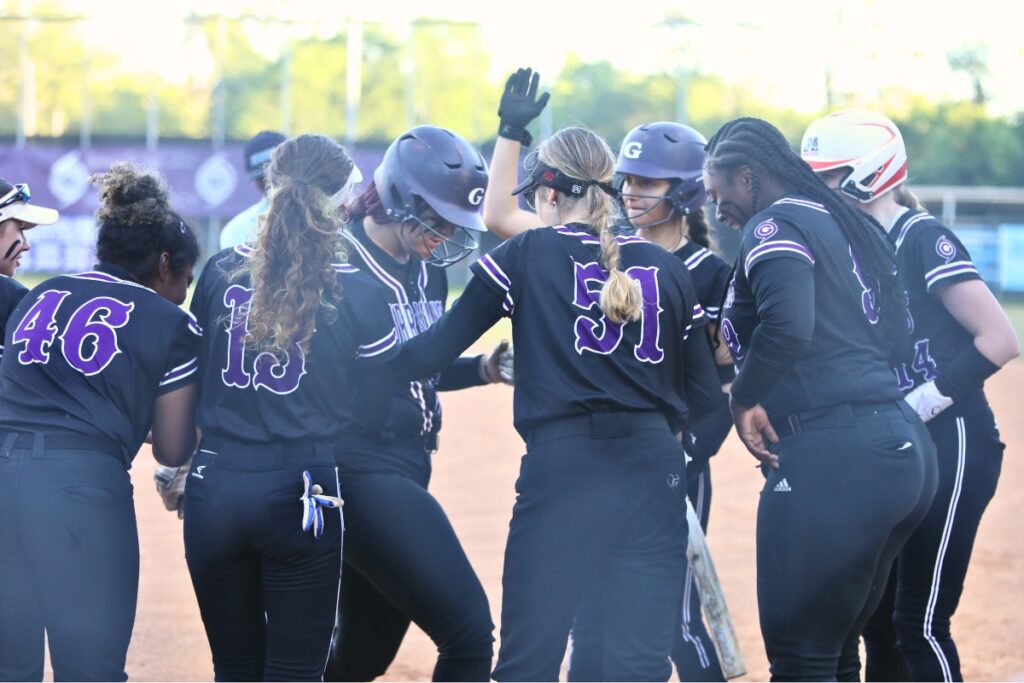 Gainesville's Braylin Cook (in helmet with head down) is congratulated by teammates after hitting a two-run home run in the bottom of the first inning against Santa Fe.