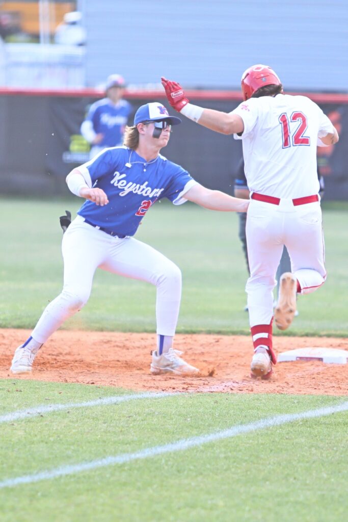 Keystone Heights' Austin Smith tags Santa Fe's Dylan Lovelace out in the bottom of the second inning.