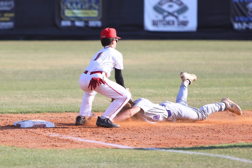 Santa Fe's Dylan Doria tags Gainesville's Broc Tucker out at third base in the top of the first inning.