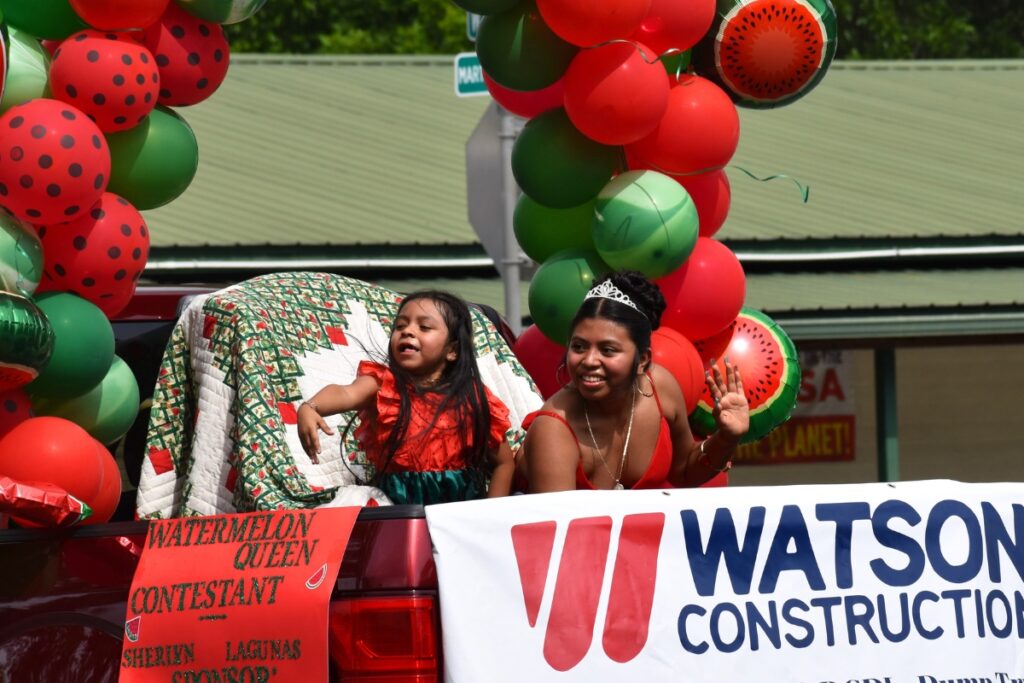 Alexa (left) and Sheriyn Lagunas throw candy and wave in the parade.
