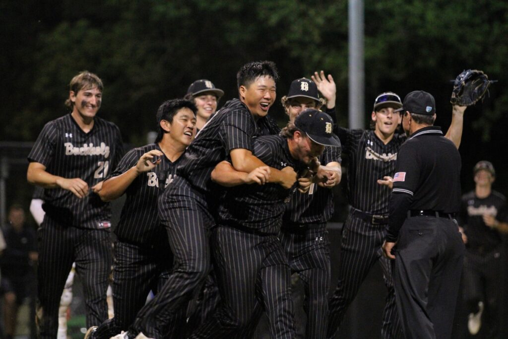 Kai So tackles pitcher Wyatt Clarke after delivering the game-ending strikeout Friday night.