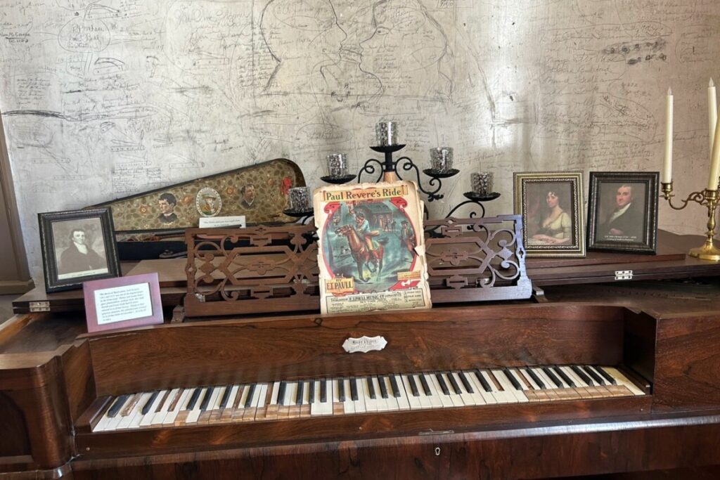 One of the original pianos in the Homestead. Behind the piano is a talking wall.
